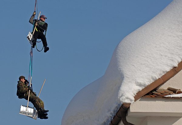 Ein Mitarbeiter der Bergwacht (oben) und Bundeswehrsoldaten werden am Montag...