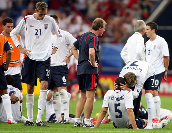 Peter Crouch (L) and his dejected English team-mates react after Portugal...