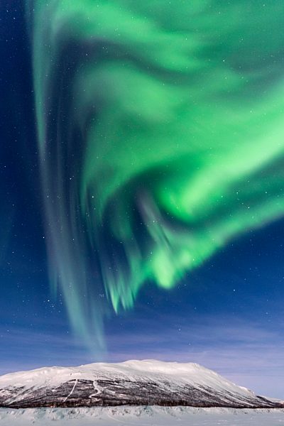 Nordlicht (Aurora Borealis) über verschneiten Bergen, Abisko Nationalpark, Abisko, Lappland, Schweden, Europa