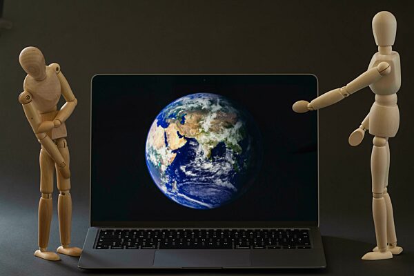 Modelpuppen beobachten den Globus auf dem Computer, Symbolfoto