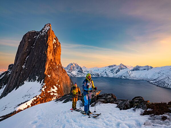 Zwei Skibergsteiger beim Aufstieg am steilen Berg Segla, Fjord Mefjorden mit Bergen, Insel Senja, Troms, Norwegen, Europa
