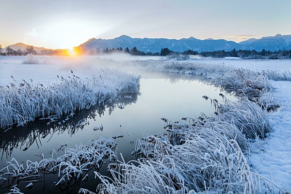 Verschneite Winterlandschaft mit der Uffinger Ach bei Sonnenaufgang mit Herzogstand 1731m und Heimgarten 1790m, Uffing am Staffelsee, Das Blaue Land, Oberbayern, Bayern, Deutschland, Europa
