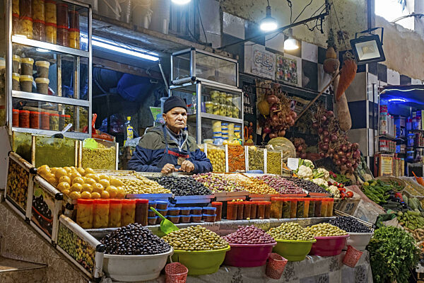 Marokkanischer Verkäufer, der Tafeloliven auf einem Lebensmittelmarkt in der...