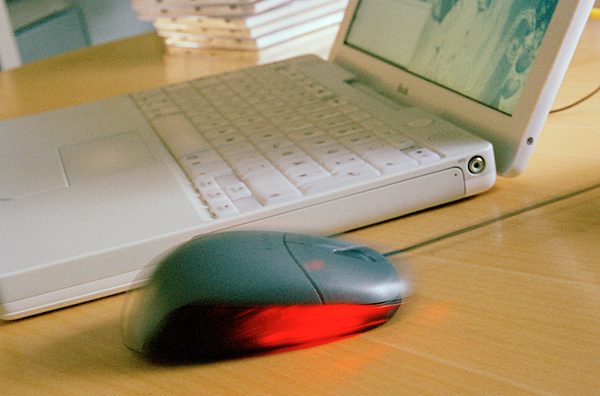 Optische Computermaus neben Laptop / Computer