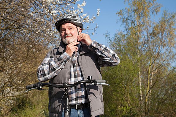Senior setzt Fahrradhelm auf, Nordrhein-Westfalen, Deutschland, Europa
