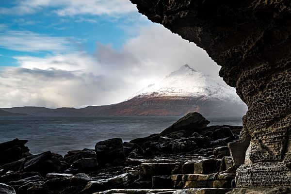 Große Felsen im Wasser der Nordsee mit verschneiten Cullin Bergen im Hintergrund, Elgol, Isle of Skye, Schottland, Großbritannien, Europa