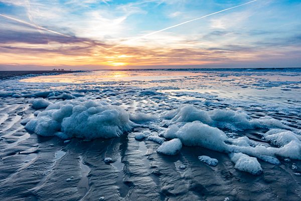 Meeresschaum bei Sonnenuntergang am Strand bei Ebbe, Nordsee, Langeoog, Ostfriesland, Niedersachsen, Deutschland, Europa