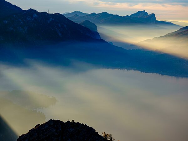 Ausblick auf Attersee und Mondsee im Dunst, unten Bergsteiger auf dem Kleinen Schoberstein, hinten die Drachenwand, Salzkammergut, Oberösterreich, Österreich, Europa