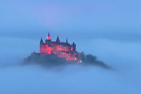 Burg Hohenzollern mit Weihnachtsbeleuchtung über dem Nebel, Hechingen, Baden-Württemberg, Deutschland, Europa