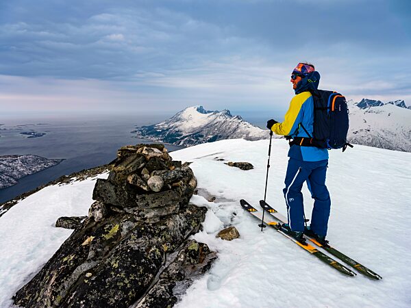 Skibergsteiger am Gipfel des Flobjörn mit Blick über den Bergsfjord, Insel Senja, Troms, Norwegen, Europa