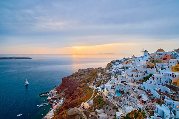 Berühmte griechische ikonischen Selfie Spot Touristenziel Oia Dorf mit traditionellen weißen Häusern und Windmühlen in Santorini Insel bei Sonnenuntergang in der Dämmerung, Griechenland, Europa