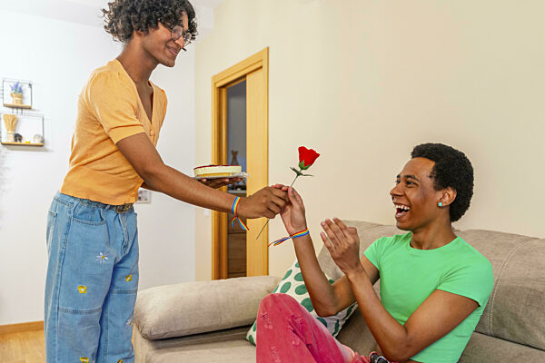 Homosexuelles Paar feiert den Valentinstag mit Blumen und Kuchen zu Hause...