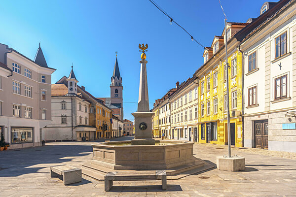 Sonnige Sommeransicht des Hauptplatzes von Kranj mit dem Brunnen und der...