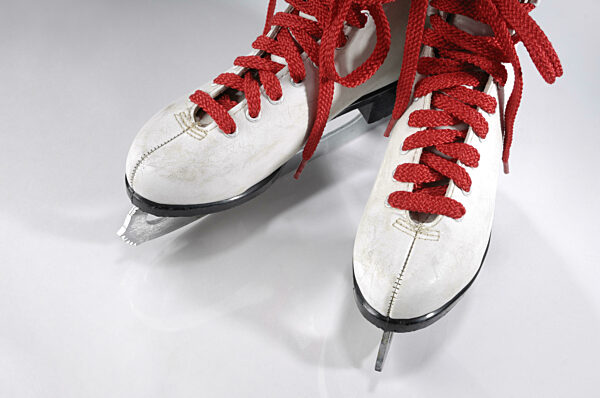 Schlittschuhe mit roten Schnürsenkeln vor weißem Hintergrund