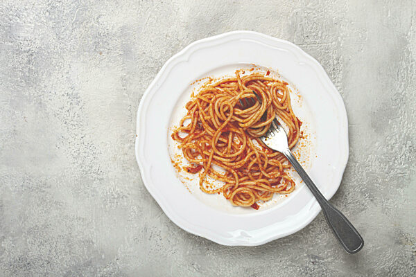 Ein Teller mit übrig gebliebenen Spaghetti Bolognese, keine Menschen