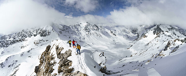 Drei Bergsteiger beim Aufstieg an schmalem Berggrat des Piz Laviner...