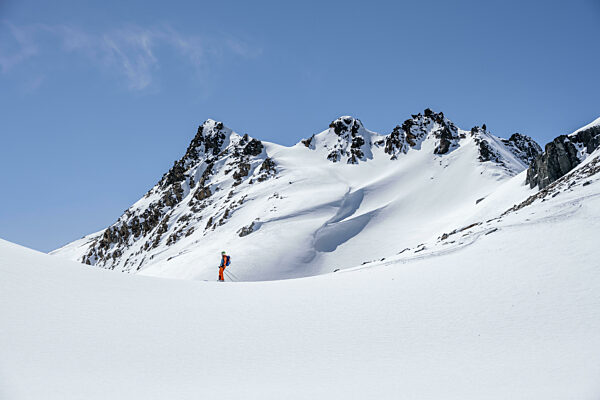 Skitourengeherin bei der Abfahrt, inimalistische Winterlandschaft...
