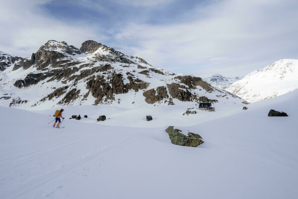 Skifahrerin bei der Abfahrt zur Berghütte Grialetschhütte im Winter...