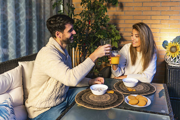 Ein junges Paar genießt ein romantisches Frühstück auf dem Balkon...