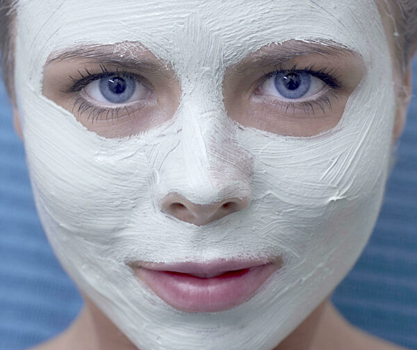 Eine Frau mit blauen Augen genießt eine Entspannungsbehandlung mit einer...