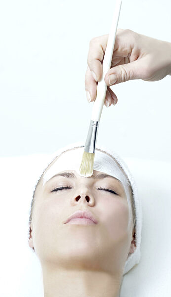 Frau genießt eine Hautmaske / Gesichtsmaske in einem Spa Pflege der Haut