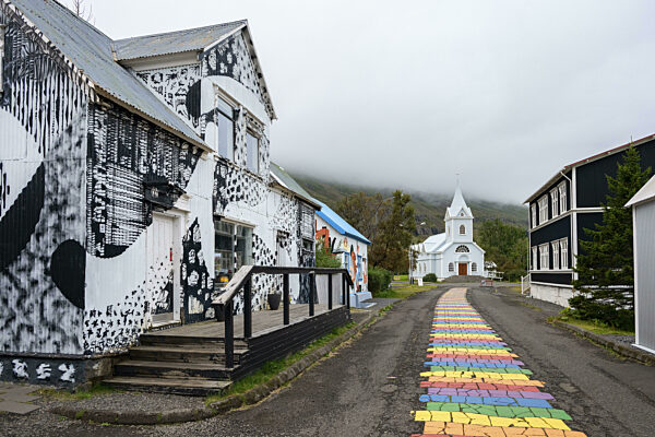 Kirche mit Regenbogen-Fußgängerweg in der Stadt Seyðisfjörður, Ostisland, Island