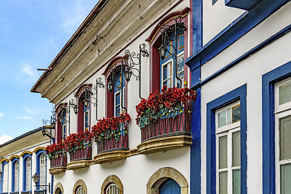 Fassade eines alten Hauses im Kolonialstil mit blühenden Balkonen in der...